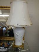 A white porcelain table lamp on a brass base.