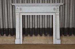 A George III painted pine fire surround in the style of Robert Adam,
