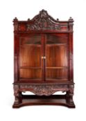 An impressive late Victorian carved mahogany serpentine display cabinet possibly by Gillows