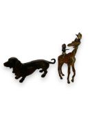 An early 20th century bronze figure of a Dauschund and a Bergman style cold painted figure of boys r