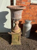 A pair of vintage terracotta urns on pedestals