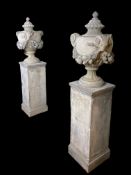A pair of classical stoneware lidded urns and covers raised on square section plinth bases