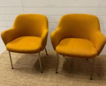 A pair of Mid Century mustard upholstered arm chairs on chrome legs