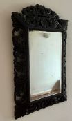 A hardwood Chinese ornate mirror with foliate design (65cm x 94cm)
