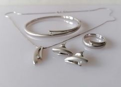 An Italian white gold parure comprising pendant chain, hinged bangle, ring and earrings