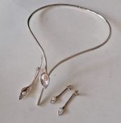 A cased Amanda Cox parure comprising silver lily torque necklace with cultured freshwater pearl