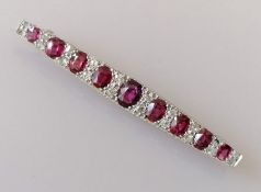 An Art Deco ruby and diamond bar brooch on a white gold setting