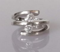 A two-stone diamond ring, each round brilliant-cut diamond weighing an estimated 0.32 carats