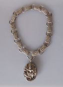 An Edwardian silver locket (55 x 45mm) and chain with profuse embossed decoration