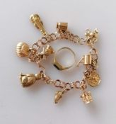 A yellow gold charm bracelet, 16.5 cm and a gold signet ring with onyx decoration, size L