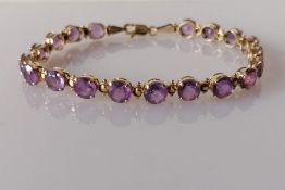 An amethyst and yellow gold line or tennis bracelet with lobster clasp