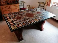 An Indian hardstone-inlaid pietra dura tabletop of oblong form on carved wooden supports