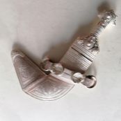An Omani traditional silver khanjar with profusely decorated waisted hilt