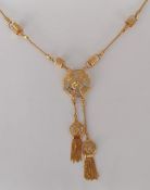A yellow and white gold integrated pendant chain with central pierced octagonal feature, tassels