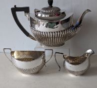 An Edwardian silver teapot with fluted decoration, ebonized knop/handle