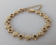 A 9ct gold bracelet with diamond and garnet floral design, hallmarked, 15.5 cm, 20g
