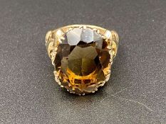 A large oval cut, smokey quartz, 9ct gold yellow gold cocktail ring,