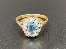 An Aquamarine & Diamond halo ring with 9ct gold mount.
