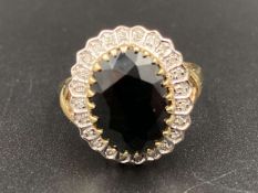 A Sapphire & Diamond cluster ring, with cross oveer shoulder design, in a 9ct gold basket setting