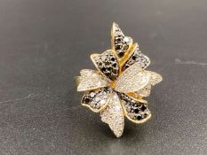 A black & clear diamond set 9ct gold foliate cluster ring.