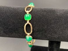 An openwork bracelet set with 5 green glass cabochons.