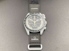 SWATCH, Moonswatch “Mission to the Moon, Gold”, bioceramic, two button quartz chronograph watch,