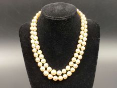 Twin strand of graduated, cultured pearls, with diamond clasp set with six old cut stones.