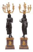 A pair of impressive patinated and gilt bronze and porphyry mounted six light candelabra,