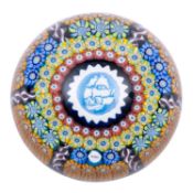 Three Perthshire paperweights comprising a small faceted pansy on a white diced gauze ground,