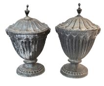 A pair of late George III lead urns and covers, early 19th century; in Neoclassical style,