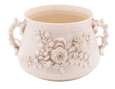 A Belleek porcelain jardiniere with rustic branch handles and applied with two large sprays of