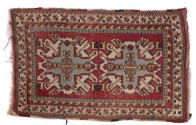 A Kurdish rug, the brick red field with ivory and pastel geometric medallions,
