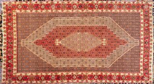 A Senneh carpet, the geometric design field with hexagonal beige and red stepped pole medallions,
