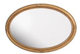 A giltwood and composition framed oval wall mirror in George III Adam style,