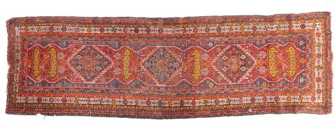 A South Persian runner, the red field with indigo hooked and stepped and geometric medallions,