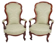 A pair of Victorian walnut and upholstered open armchairs,