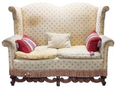 A walnut and upholstered high back wing sofa in William & Mary taste,