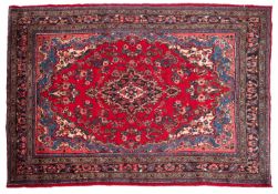 A Hamadan carpet, the red shaped lozenge field with a central indigo lozenge pole medallion,