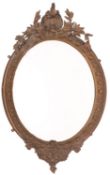 A Victorian gilt composition framed oval wall mirror, in Rococo Revival taste,