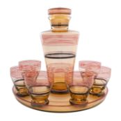 An Art Deco glass cocktail set, of pale amber colour with red and black banded decoration,
