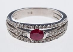 A diamond and ruby ring the central oval faceted stone with split band in 18ct white gold