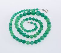 A Jadeite jade bead necklace, beads graduating in size from 5 to 12 mm, strung to a bolt ring clasp,