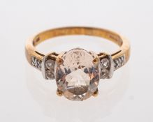 A pale peach coloured morganite ring with white sapphire set shoulders.