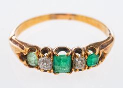 An Edwardian emerald and diamond ring set with two old cut diamonds,each 0.