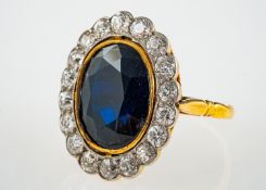 A dark blue sapphire and diamond ring, the oval faceted sapphire estimated at 7.