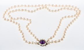 A cultured pearl necklace of two rows,strung to a silver clasp set with a cabouchon amethyst.