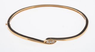 A contemporary gold hinged bangle set with three small diamonds, interior size 5.