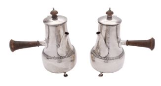 A pair of Arts and Crafts hammered silver cafe au lait pots by Phillip Hanson Abbott.