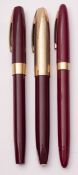 Three Sheaffer (Australia) burgundy and gilt fountain pens, all with 14k gold nibs.