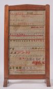 An early 20th Century child's woolwork sampler made into a fire guard,
